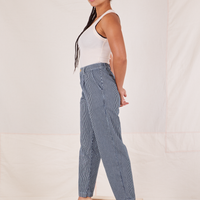 Side view of Denim Trouser Jeans in Railroad Stripe and vintage off-white Tank Top worn by Gabi