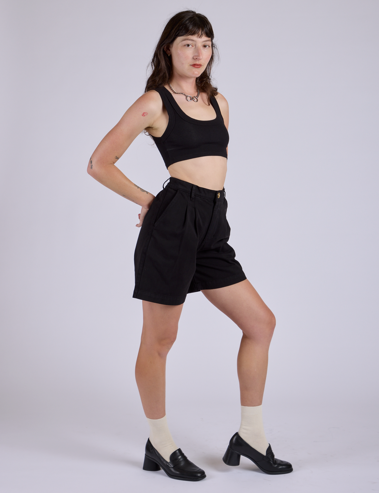 Angled front view of Pleated Trouser Shorts in Basic Black and black Mini Tank on Alex