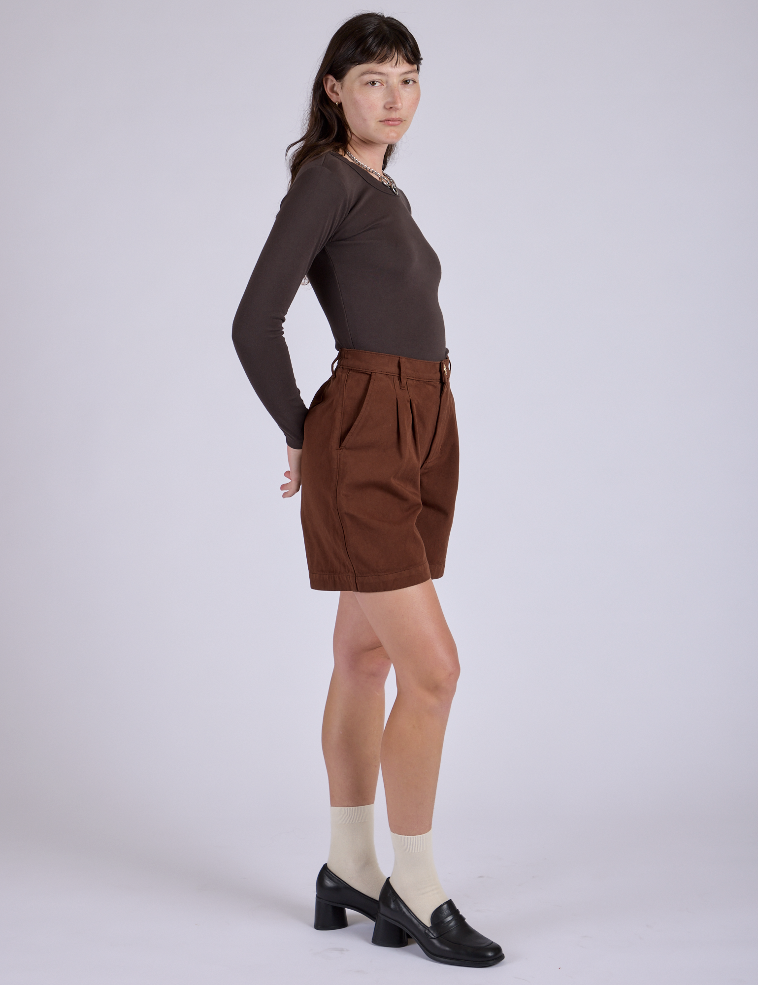 Side view of Pleated Trouser Shorts in Fudgesicle Brown and Long Sleeve Baby Tee in Espresso Brown
