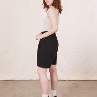 Side view of Trouser Shorts in Basic Black and a vintage off-white Tank Top worn by Hana