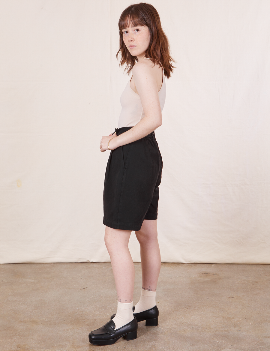 Side view of Trouser Shorts in Basic Black and a vintage off-white Tank Top worn by Hana