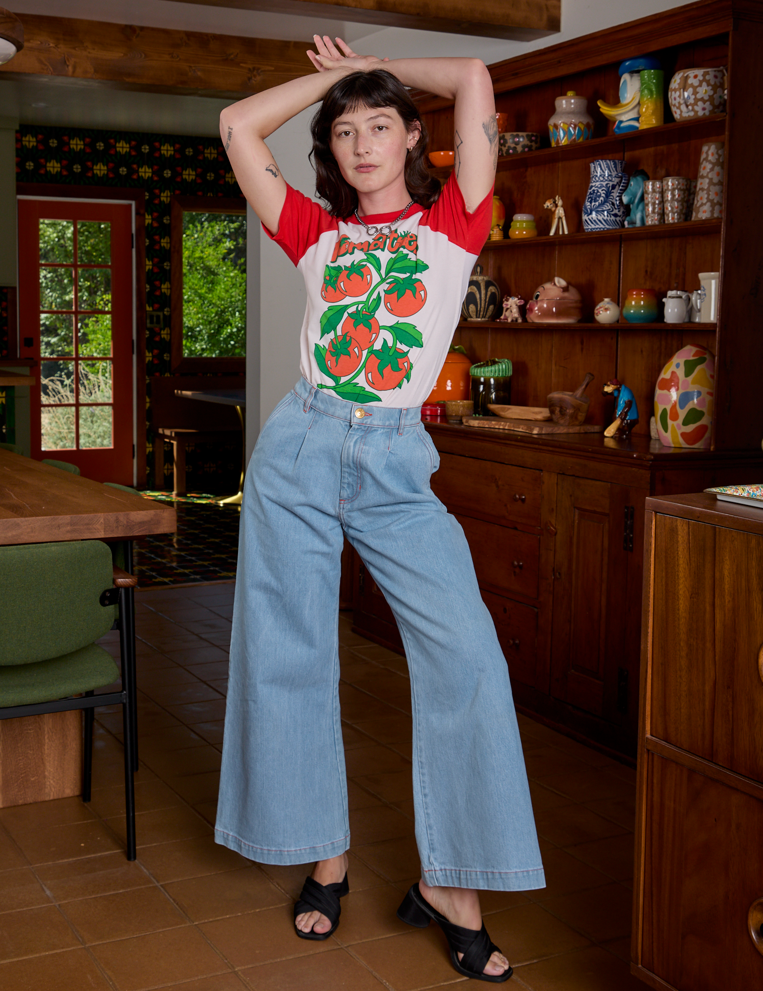 Alex is wearing Short Sleeve Raglan Tee in Tomatoes tucked into light wash Indigo Wide Leg Trousers