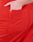 Close up of Lish's hand in the back pocket of Western Pants in Mustang Red