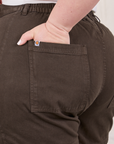 Classic Work Shorts in Espresso Brown back pocket close up. Ashley has her hand in the pocket.