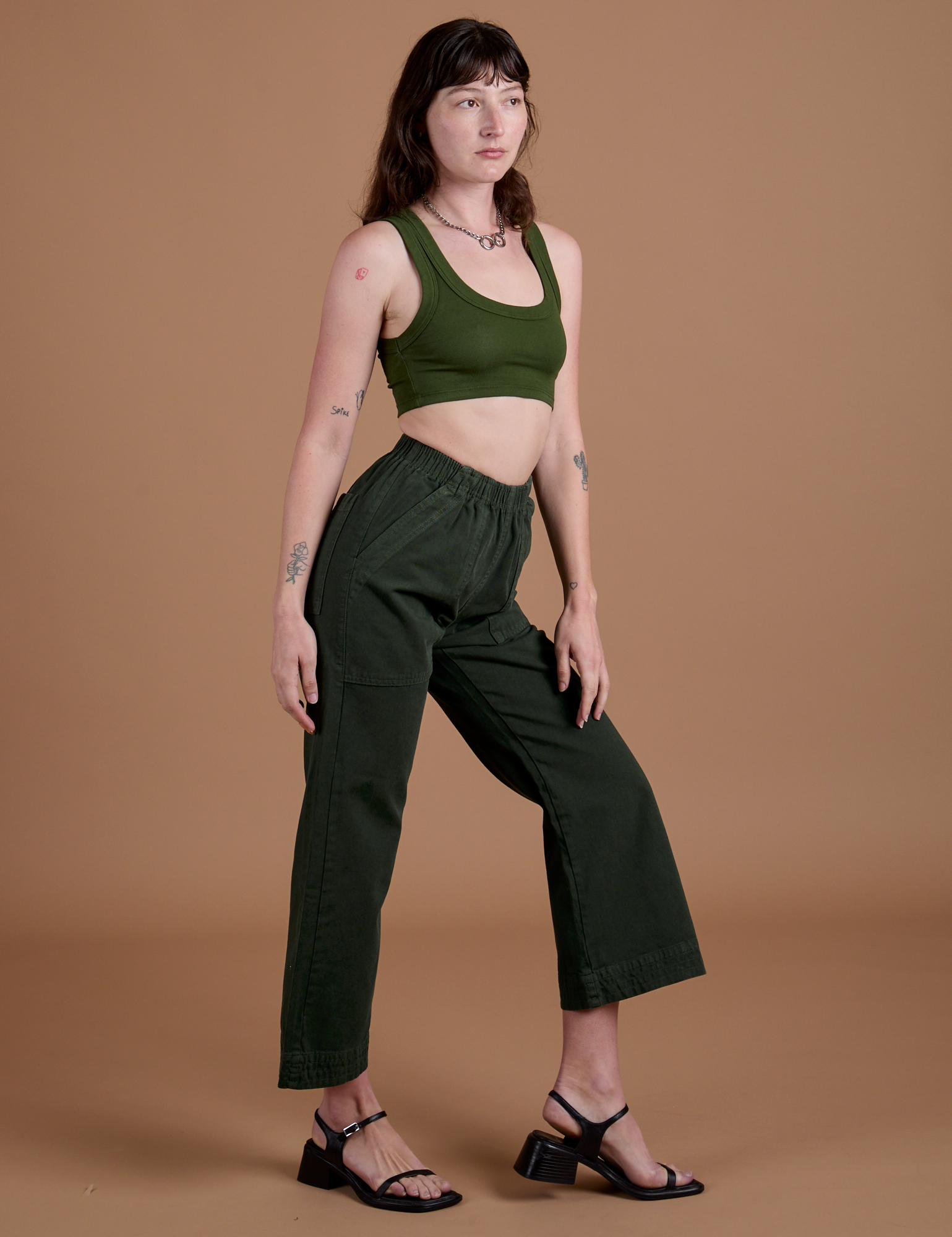 Side view of Action Pants in Swamp Green and evergreen Mini Tank on Alex