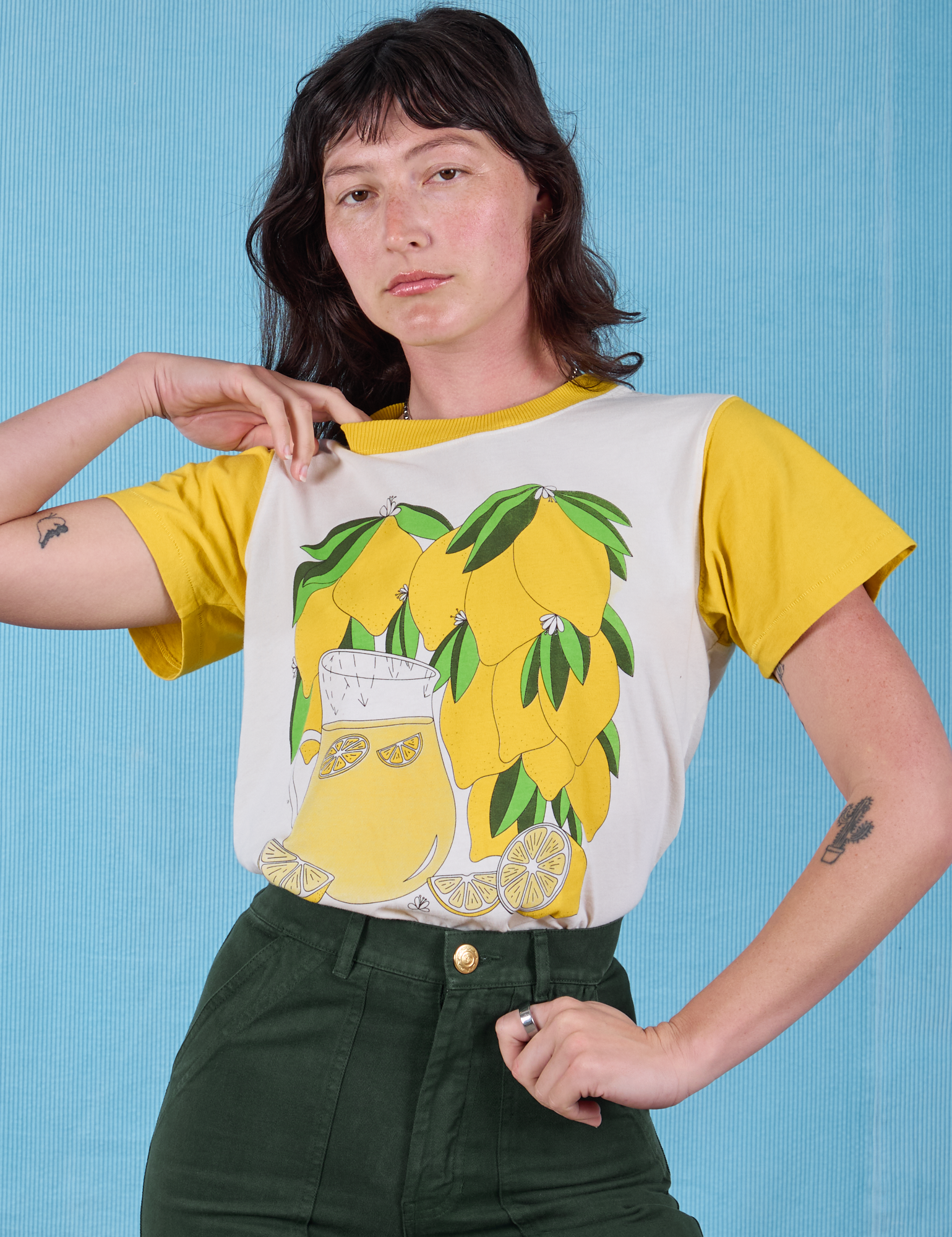 Alex is wearing Anniversary Tee in Lemon tucked in swamp green Work Pants