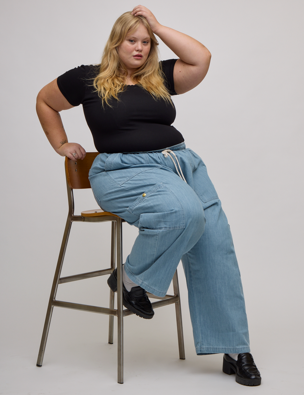 Juliet is wearing light wash denim drop pocket pants and Baby Tee in Basic Black