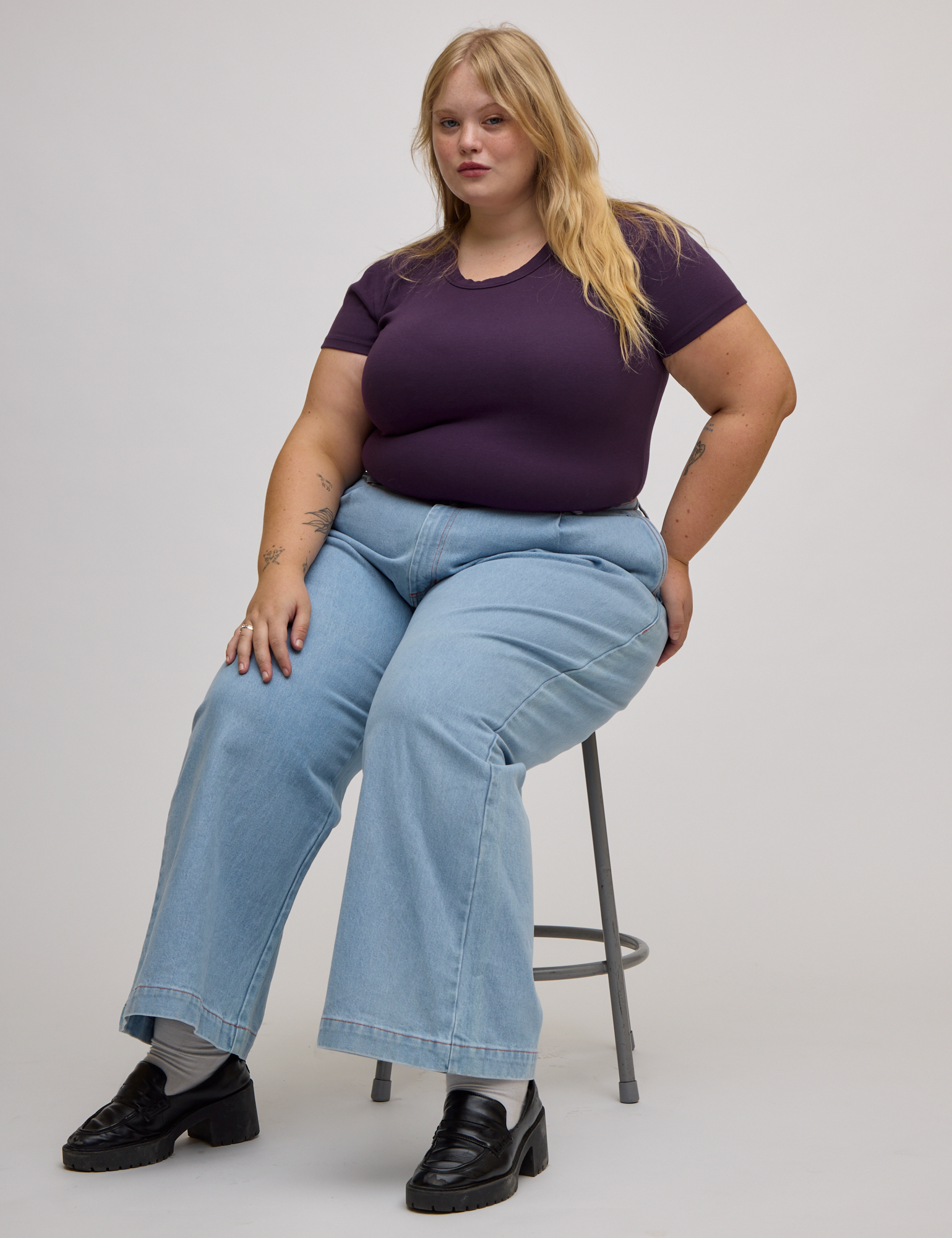Baby Tee in Nebula Purple and light wash wide leg trousers on Juliet