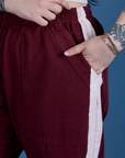 Close up of Sydney's hand in the front pocket of Painted Action Pants in Red Wine