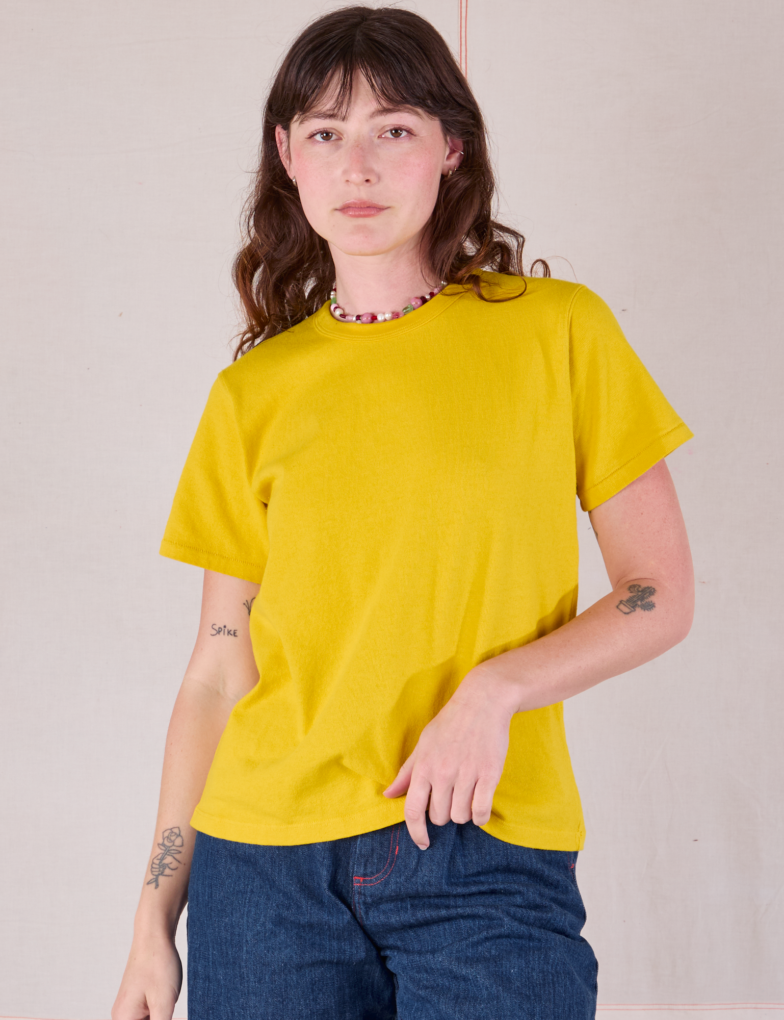 Alex is 5&#39;8&quot; and wearing P Burly Tee in Golden Yellow