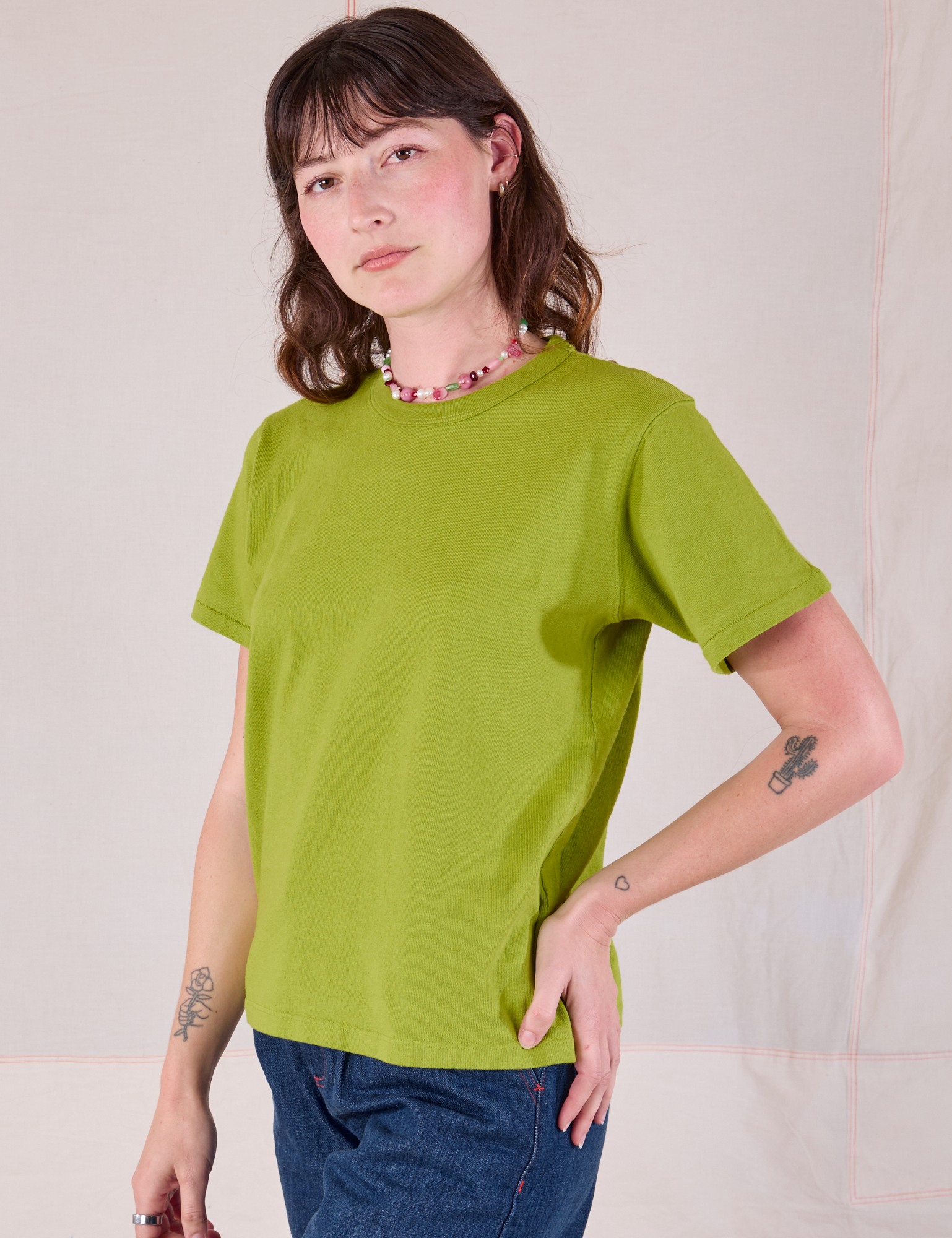 Burly Tee in Gross Green angled front view on Alex