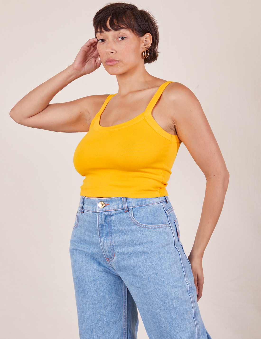 Angled view of Cropped Cami in Sunshine Yellow and light wash Sailor Jeans worn by Tiara