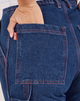 Carpenter Jeans in Dark Wash back pocket close up. Tiara has her hand in the pocket.