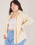 Angled front view of Corduroy Overshirt in Vintage Off-White with a vintage off-white Cropped Cami worn underneath and light wash Denim Trouser Jeans