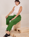 Tiara is sitting on a wooden crate. She is wearing Heavyweight Trousers in Lawn Green and vintage off-white Sleeveless Turtleneck