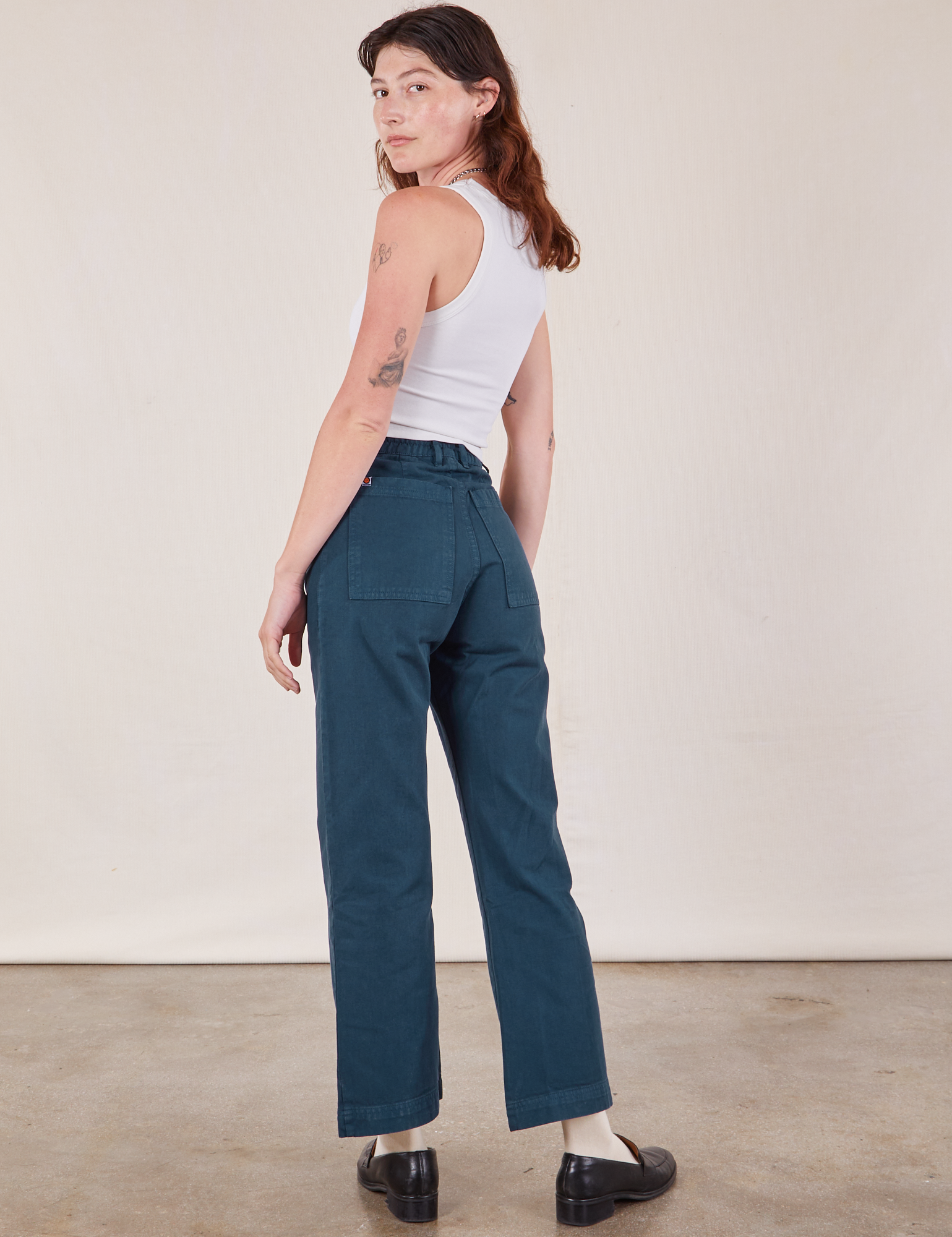 Angled view of Western Pants in Lagoon and vintage tee off-white Tank Top on Alex