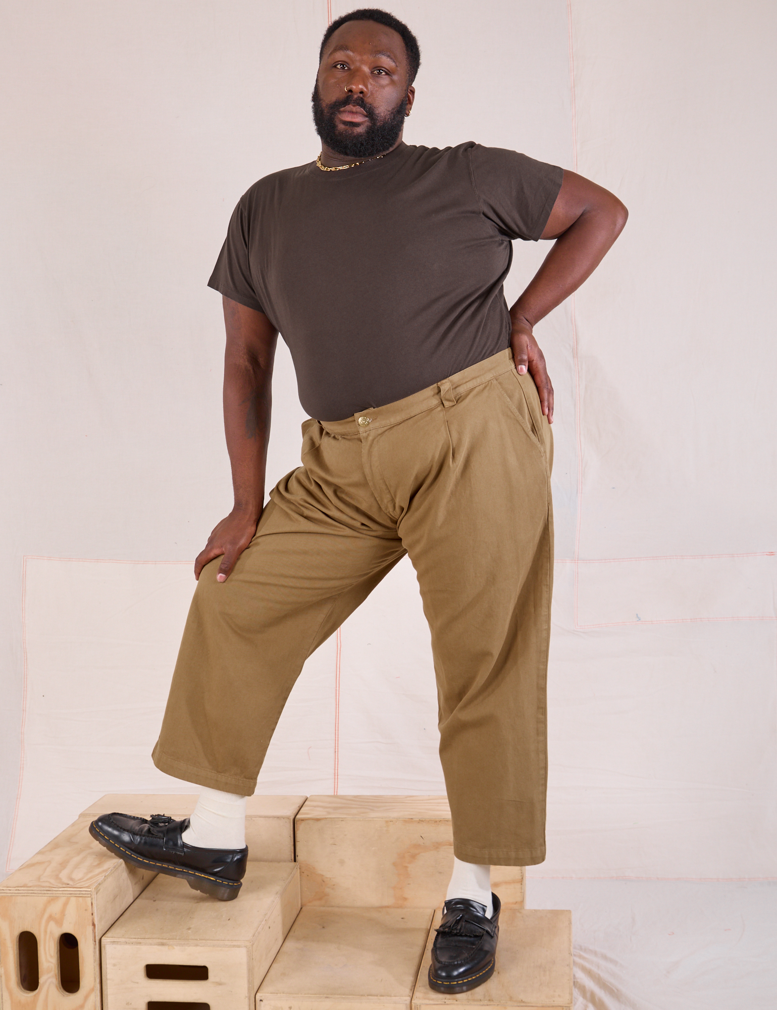 Elijah is 6&#39;3&quot; and wearing 1XL Mid-Rise Pleated Trousers in Desert Brown paired with an espresso brown Organic Vintage Tee