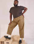 Elijah is 6'3" and wearing 1XL Mid-Rise Pleated Trousers in Desert Brown paired with an espresso brown Organic Vintage Tee