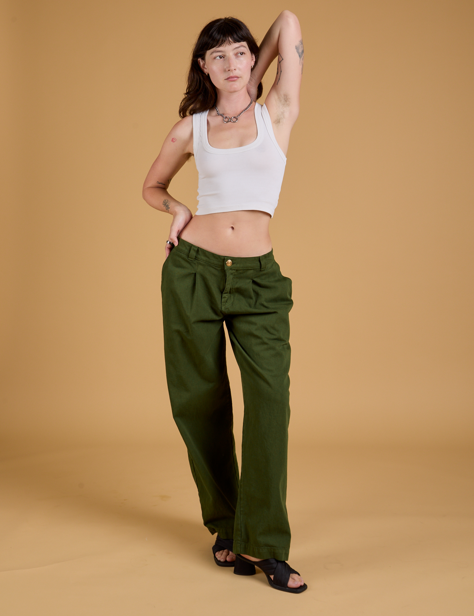 Alex is 5&#39;8&quot; and wearing XXS Baggy Mid-Rise Trousers in Evergreen paired with a vintage tee white Cropped Tank
