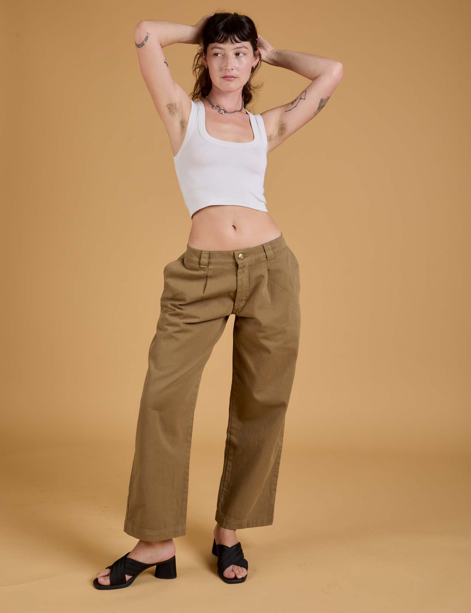 Alex is wearing Baggy Mid-Rise Trousers in Desert Brown and vintage tee white Cropped Tank 
