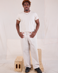 Issac is 5'10" and wearing M Mid-Rise Pleated Trousers in Stone White paired with Organic Vintage Tee in vintage tee off-white