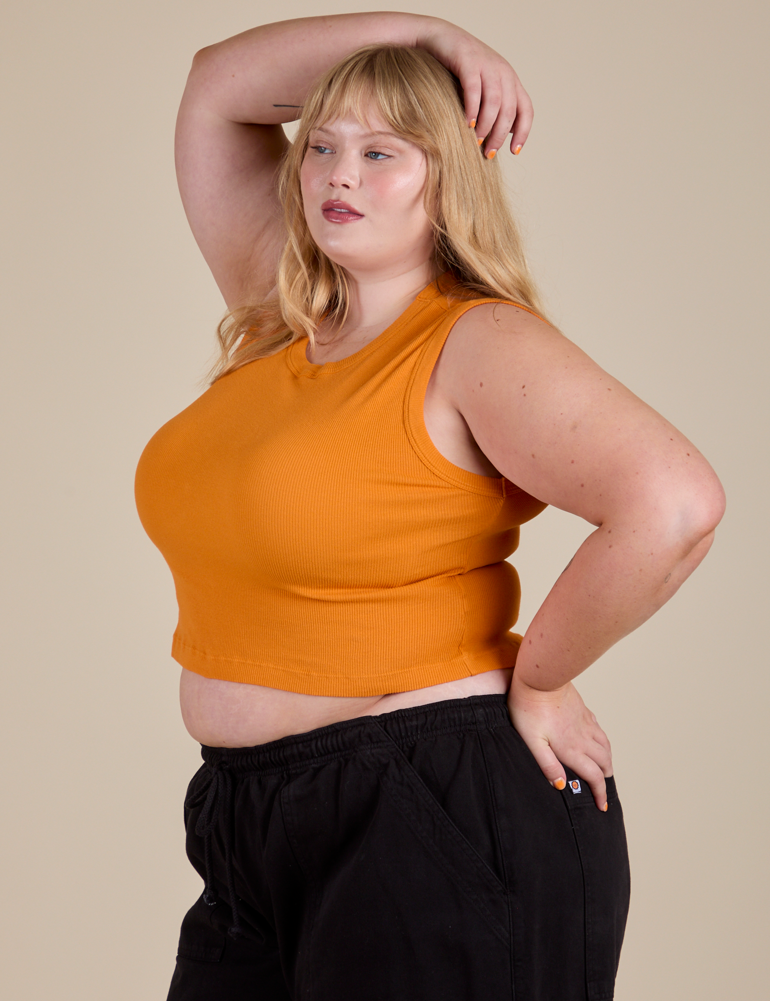 Angled front view of  Muscle Tee in Creamsicle Orange on Juliet