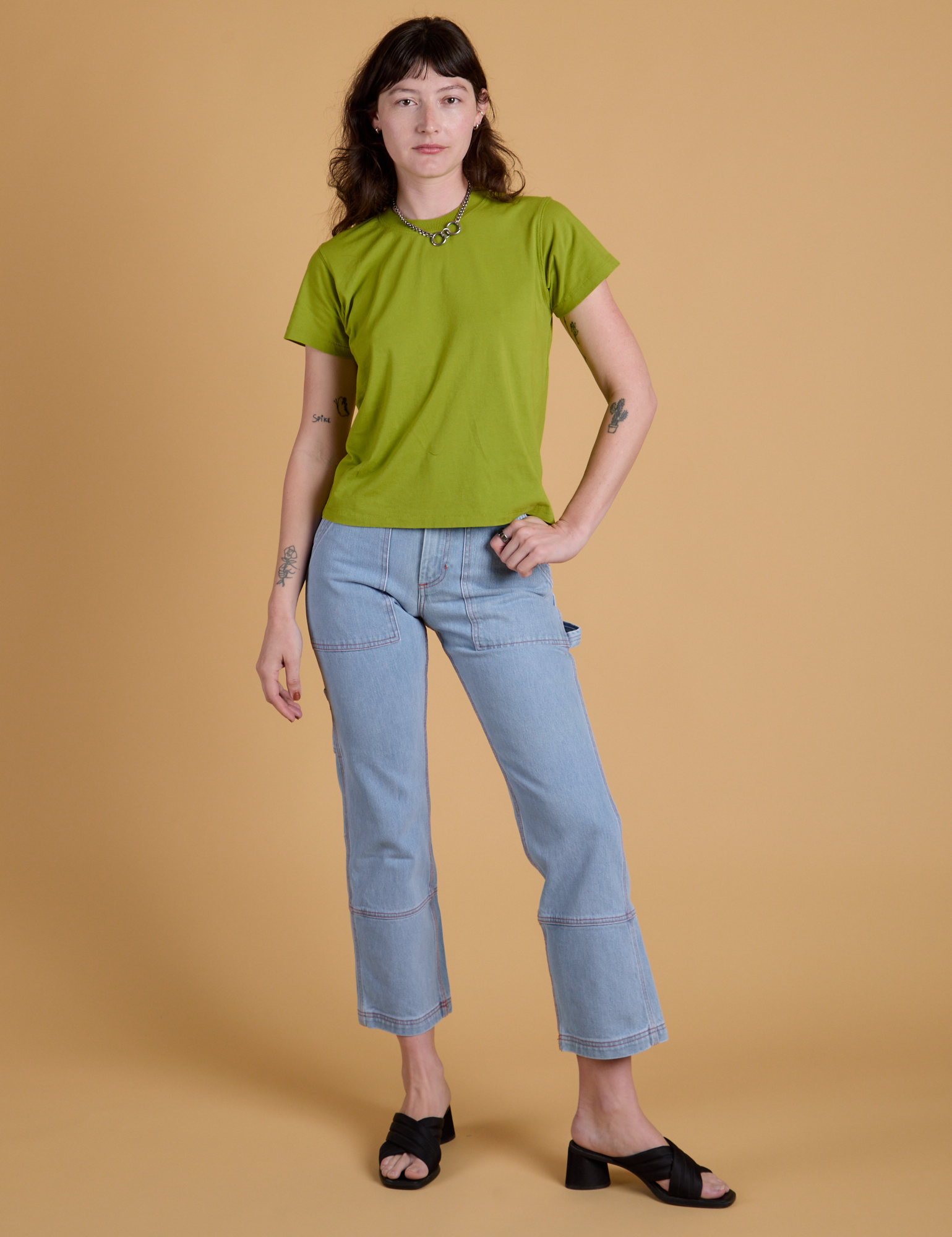 Alex is wearing Organic Vintage Tee in Gross Green and light wash Carpenter Jeans