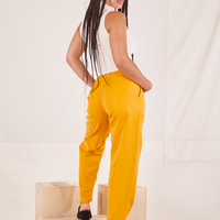Back view of Organic Trousers in Mustard Yellow worn by Gabi