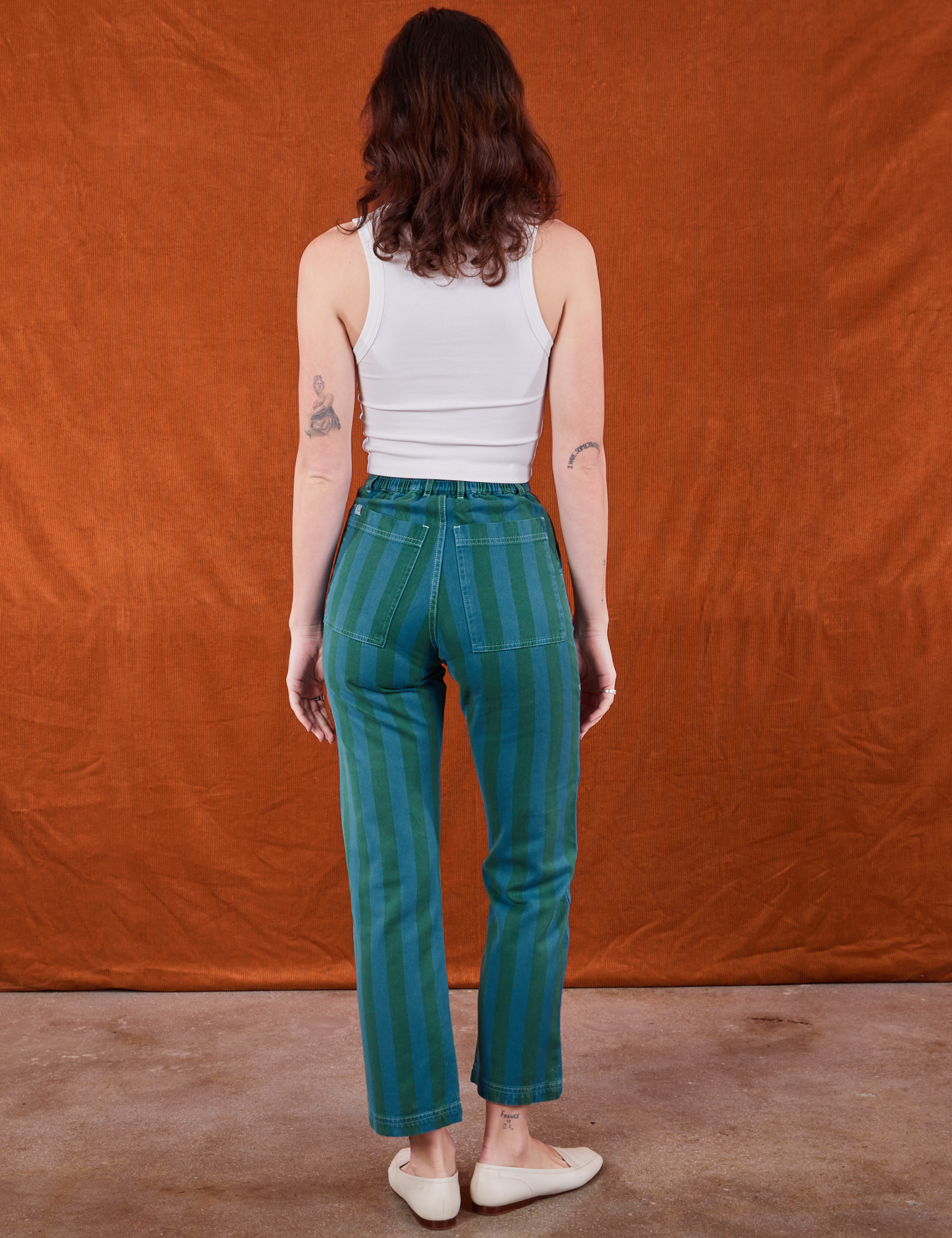 Back view of Overdye Stripe Work Pants in Blue/Green and vintage off-white Cropped Tank Top on Alex