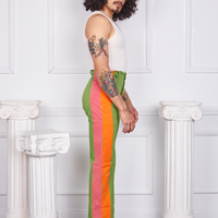 Side view of Hand-Painted Stripe Western Pants in Bright Olive and vintage off-white Tank Top. Pink and orange hand painted stripe along the side of the pant