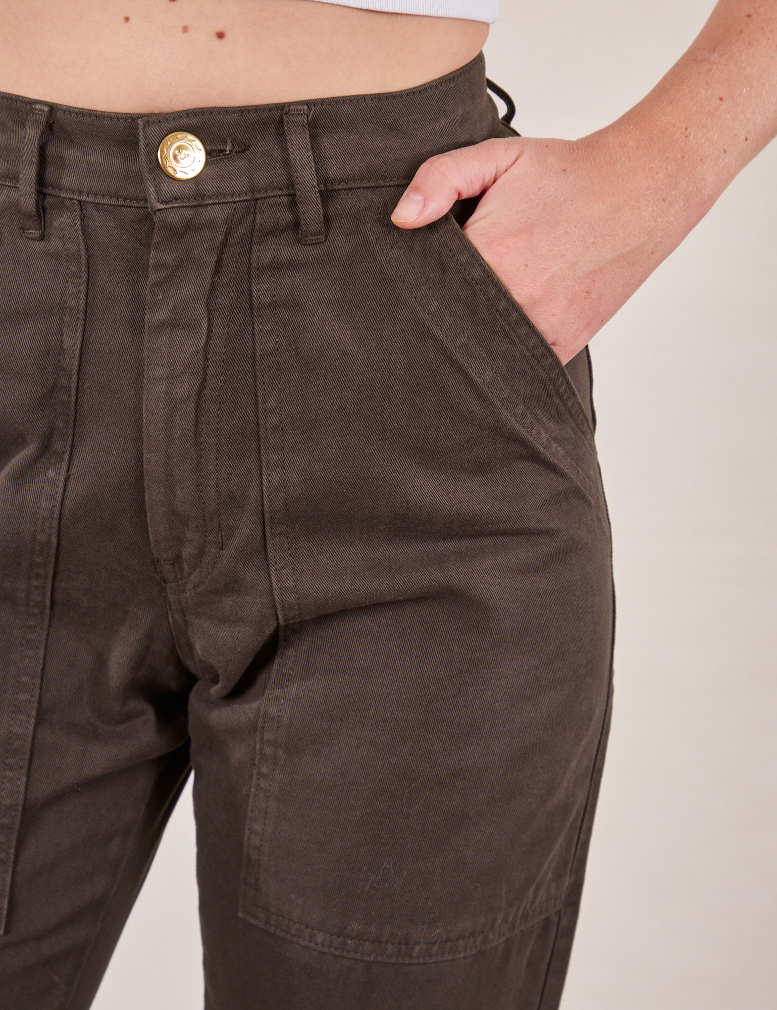 Pencil Pants in Espresso Brown front pocket close up. Scarlett has her hand in the pocket.