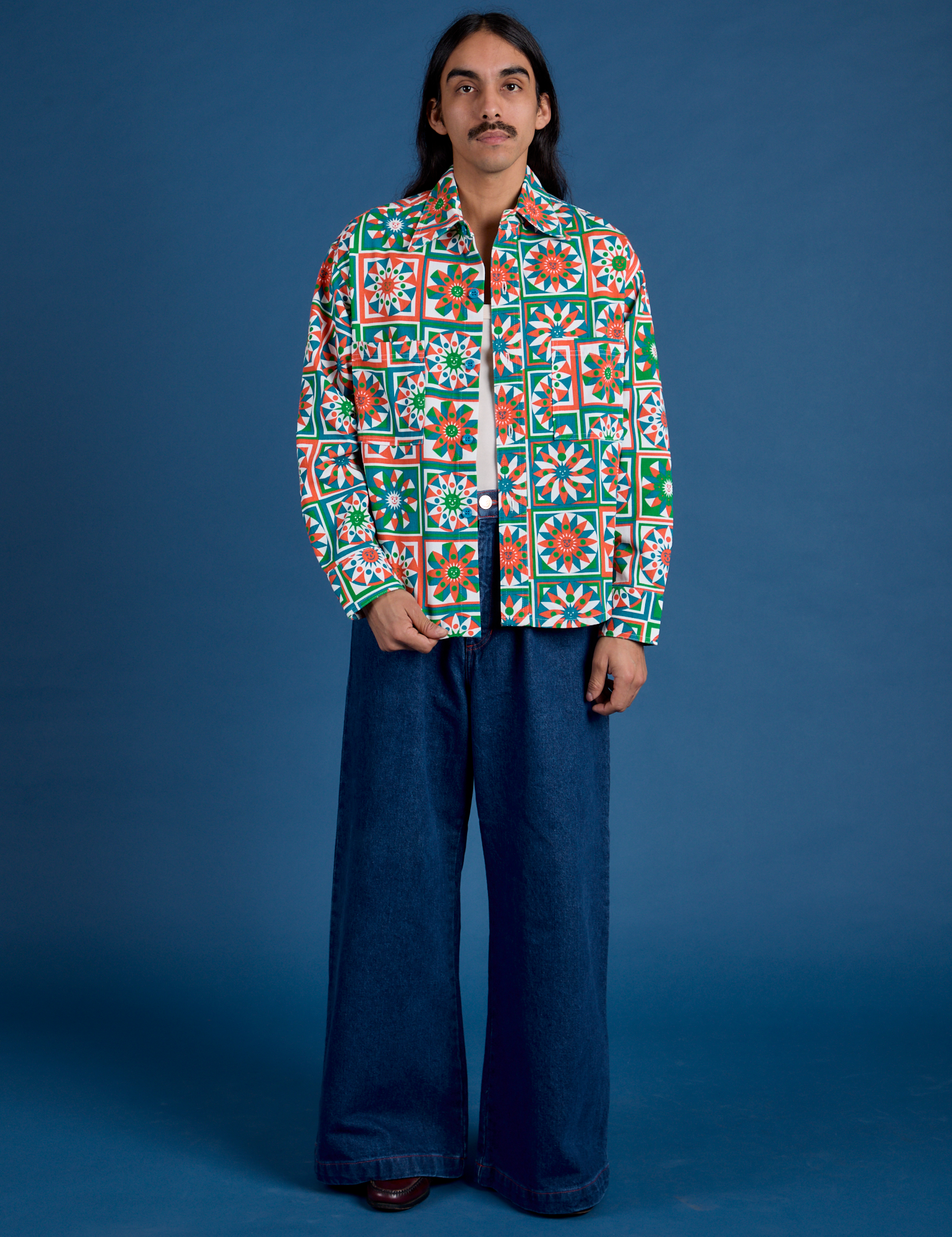 Anthony is 5’6” and wearing S Cropped Overshirt in Quilt Print paired with dark wash Indigo Wide Leg Trousers