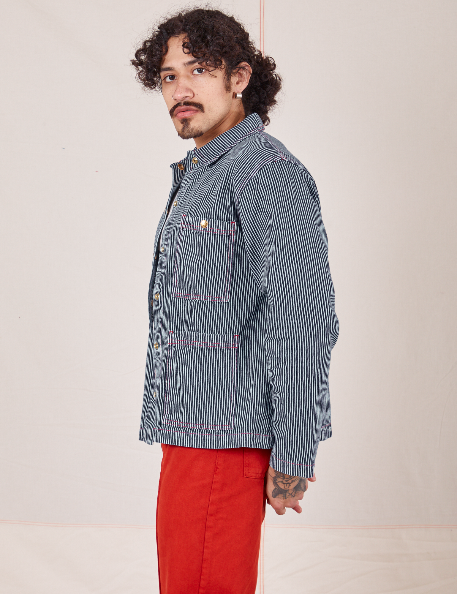 Side view of Railroad Stripe Denim Work Jacket paired with paprika Western Pants worn by Jesse