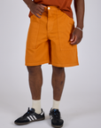 Longline Work Shorts in Creamsicle Orange front close up on Isaac