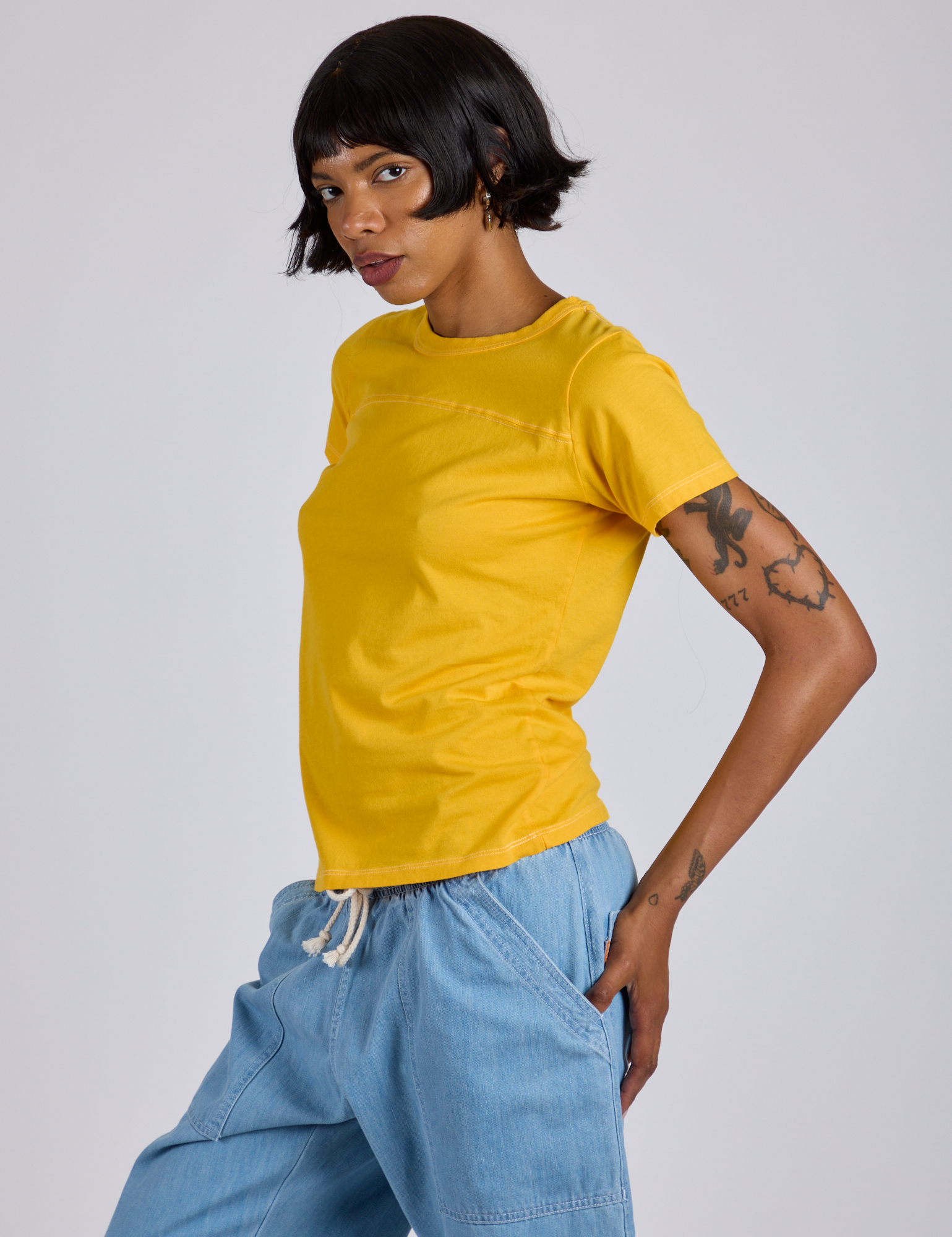 Angled front view of Jr. Varsity Tee in Sunshine Yellow on Kira