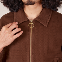Front close up of the Ricky Jacket in Fudgesicle Brown worn by Jesse. Brass zipper and ring pull.