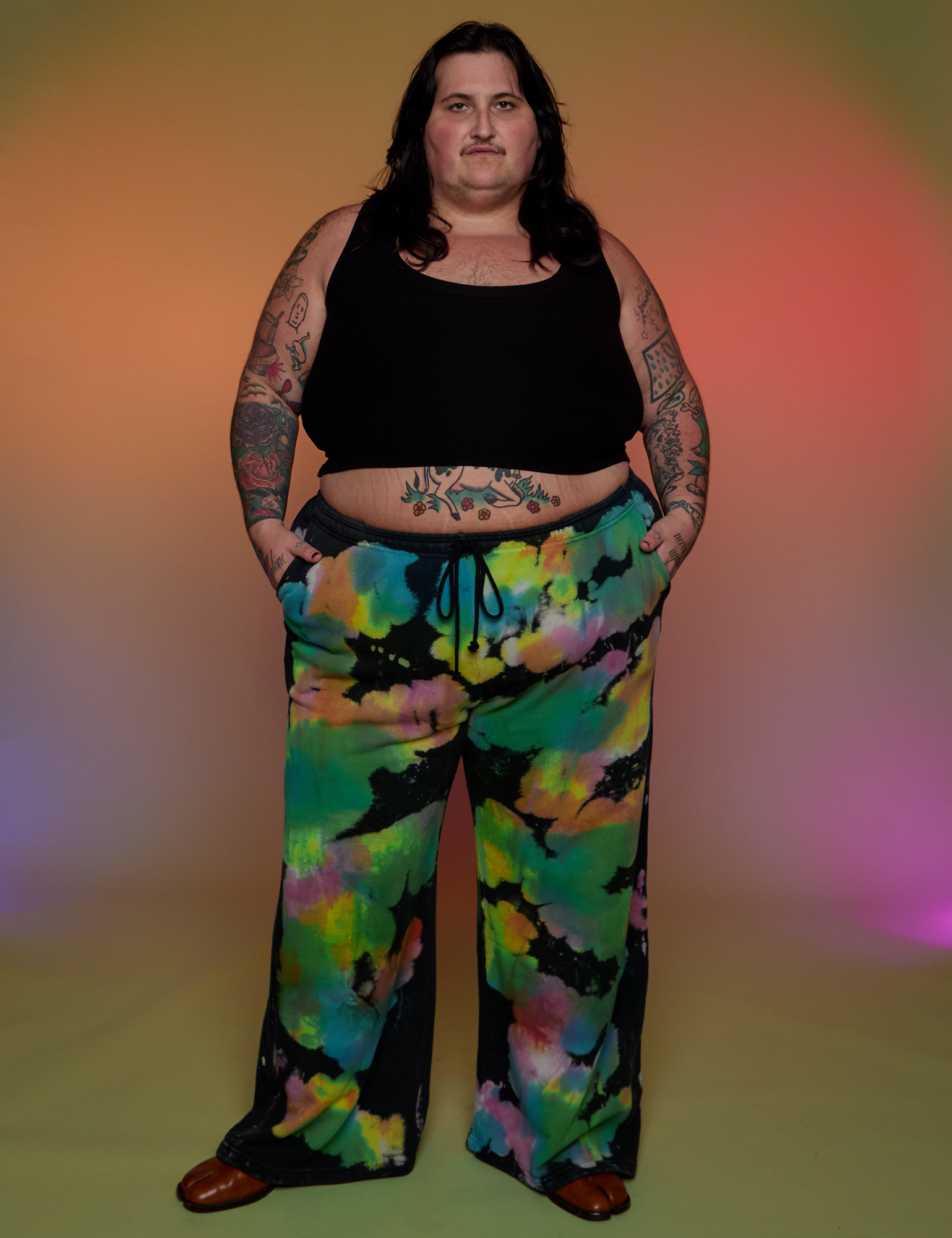 Sam is 5’10” and wearing 1XL Tie Dyed Wide Leg Sweat Pants paired with black Cropped Tank