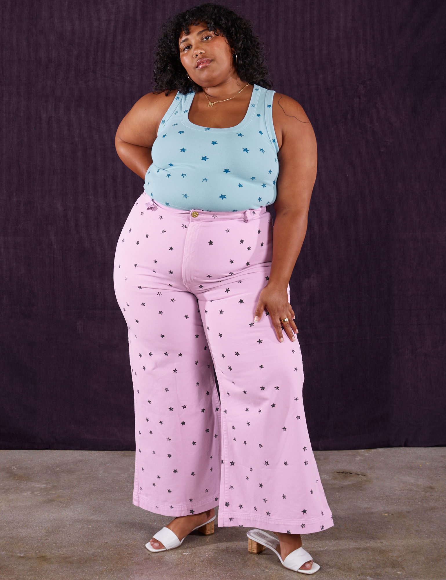 Morgan is wearing Star Bell Bottoms in Lilac Purple and Star Cropped Tank in blue