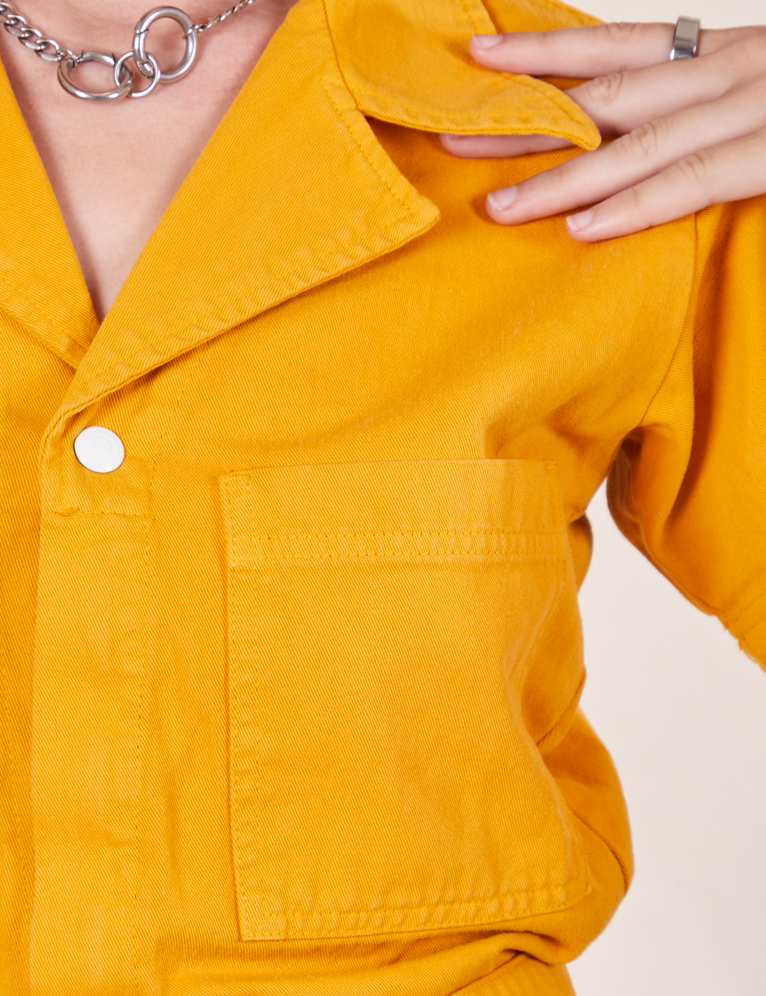 Front close up of Short Sleeve Jumpsuit in Mustard Yellow worn by Alex