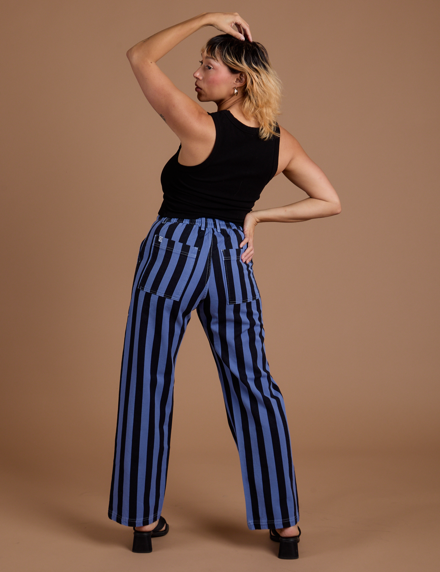 Back view of Black Stripe Work Pants in Cornflower Blue and black Cropped Tank on Tiara