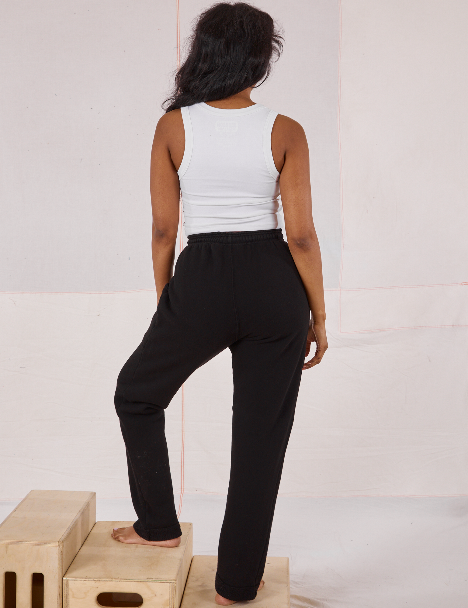 Back view of Rolled Cuff Sweat Pants in Basic Black and vintage off-white Cropped Tank on Kandia