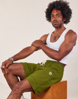 Jerrod is wearing Lightweight Sweat Shorts in Summer Olive and Cropped Tank in vintage tee off-white