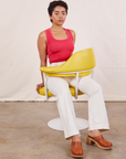 Mika is sitting in a yellow chair wearing Tank Top in Hot Pink and vintage off-white Western Pants