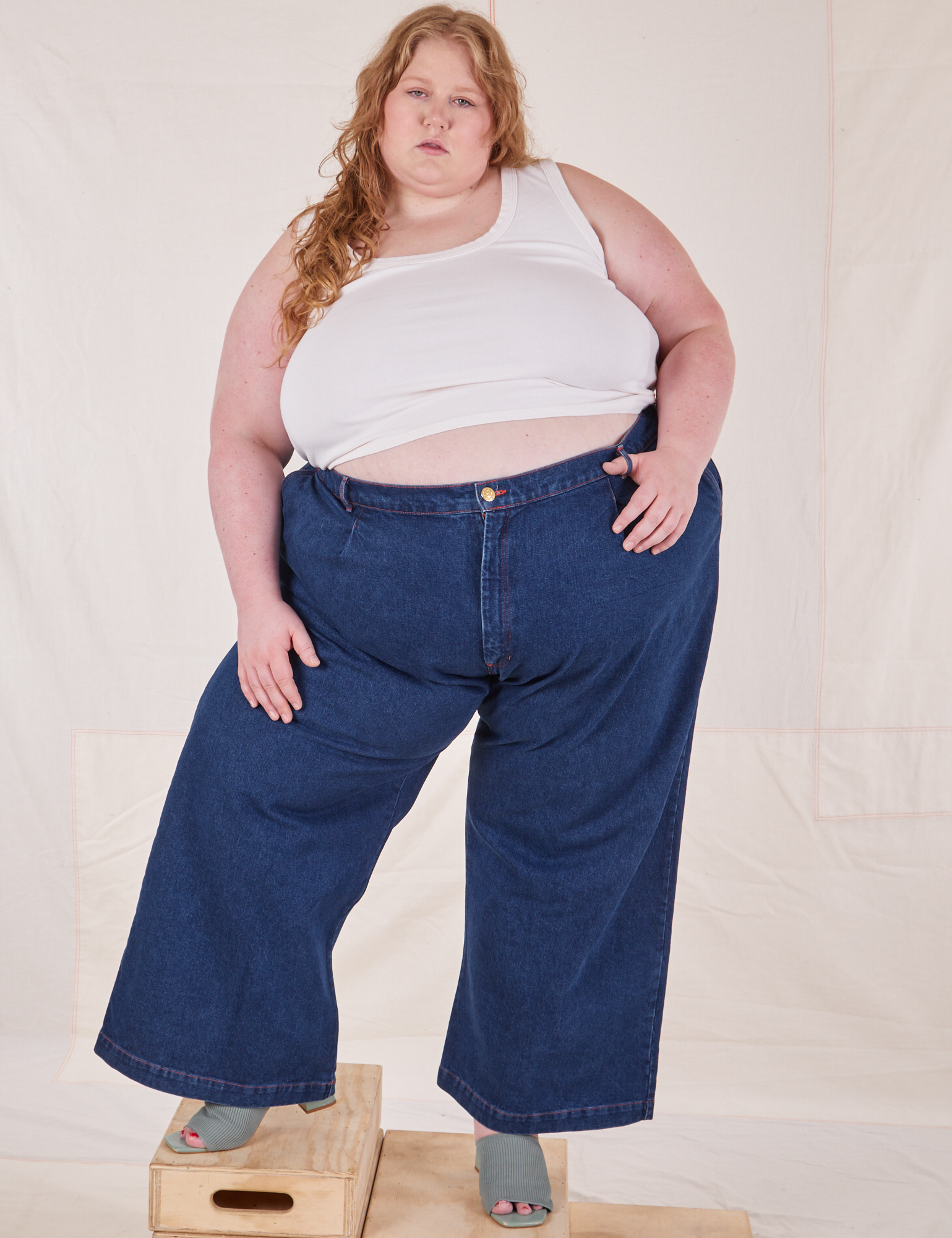 Catie is 5&#39;11&quot; and wearing 4XL Indigo Wide Leg Trousers in Dark Wash paired with vintage off-white Cropped Tank Top