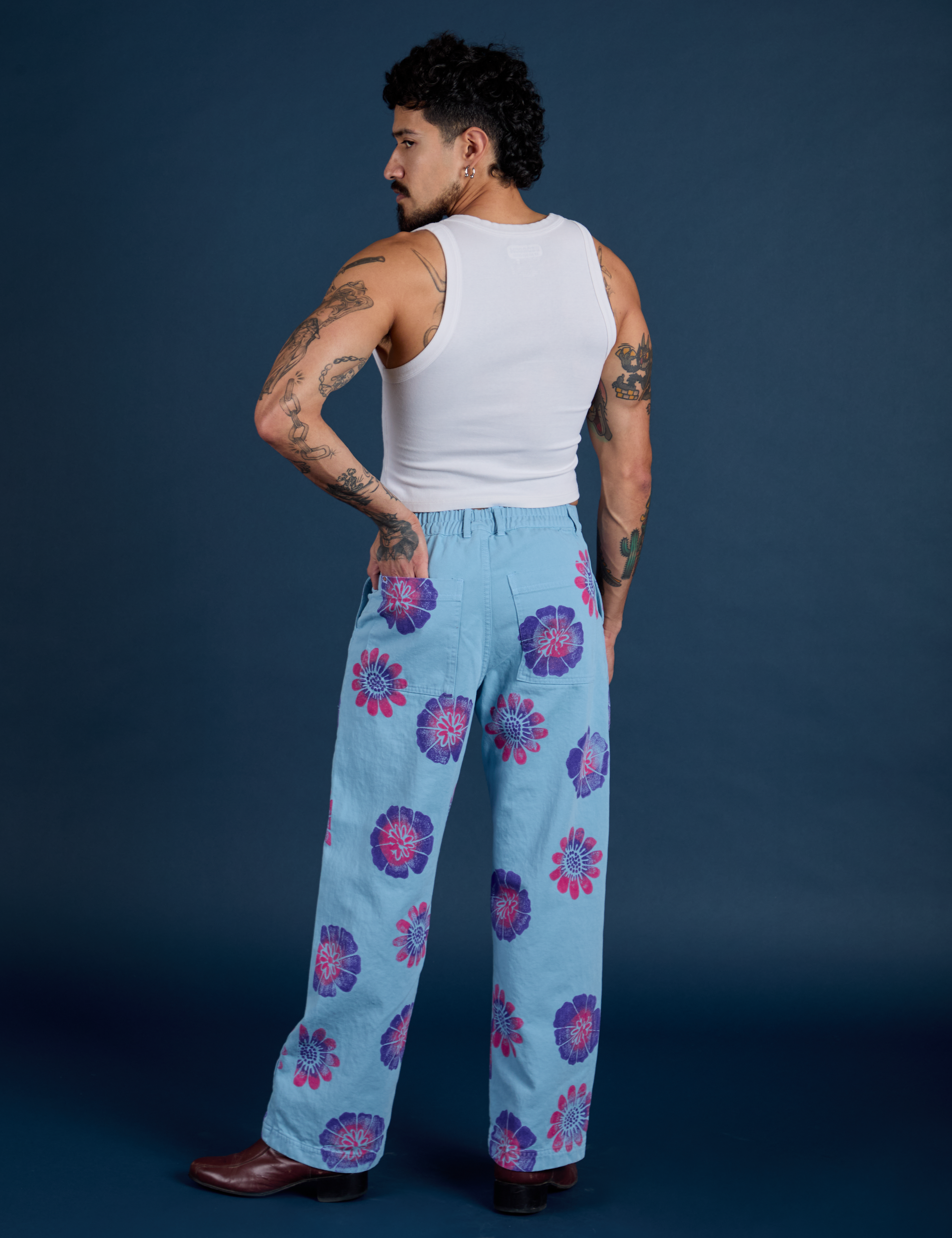 Back view of Floral Painted Work Pants in Blue and Cropped Tank in Vintage Tee White on Jesse