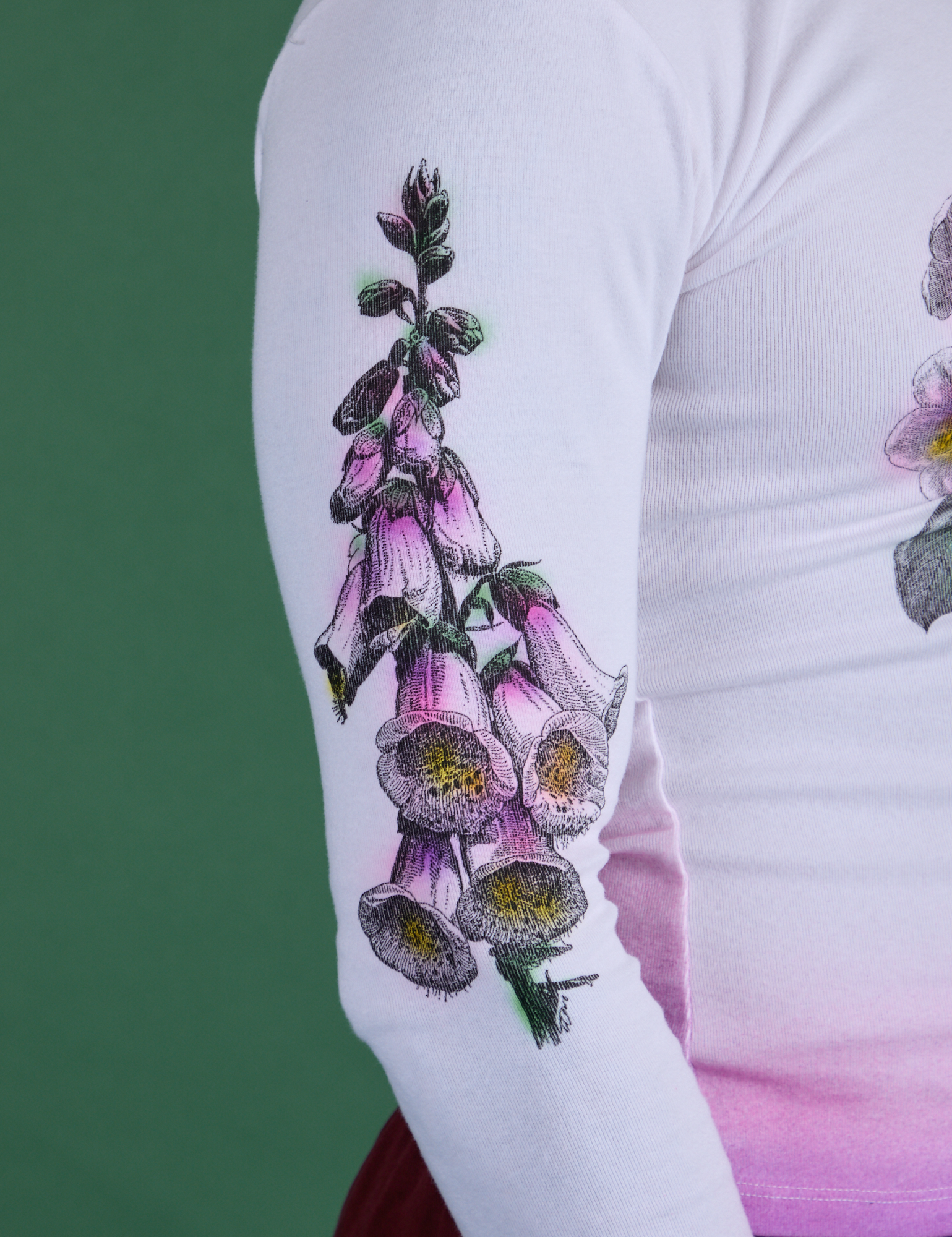 Close up of screen-print flower on sleeve of Floral Long Sleeve Baby Tee in Pink