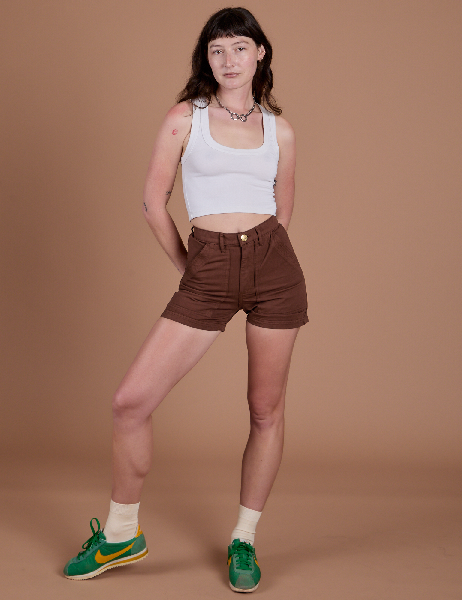 Alex is wearing Classic Work Shorts in Fudgesicle Brown and a Cropped Tank in Vintage Tee White