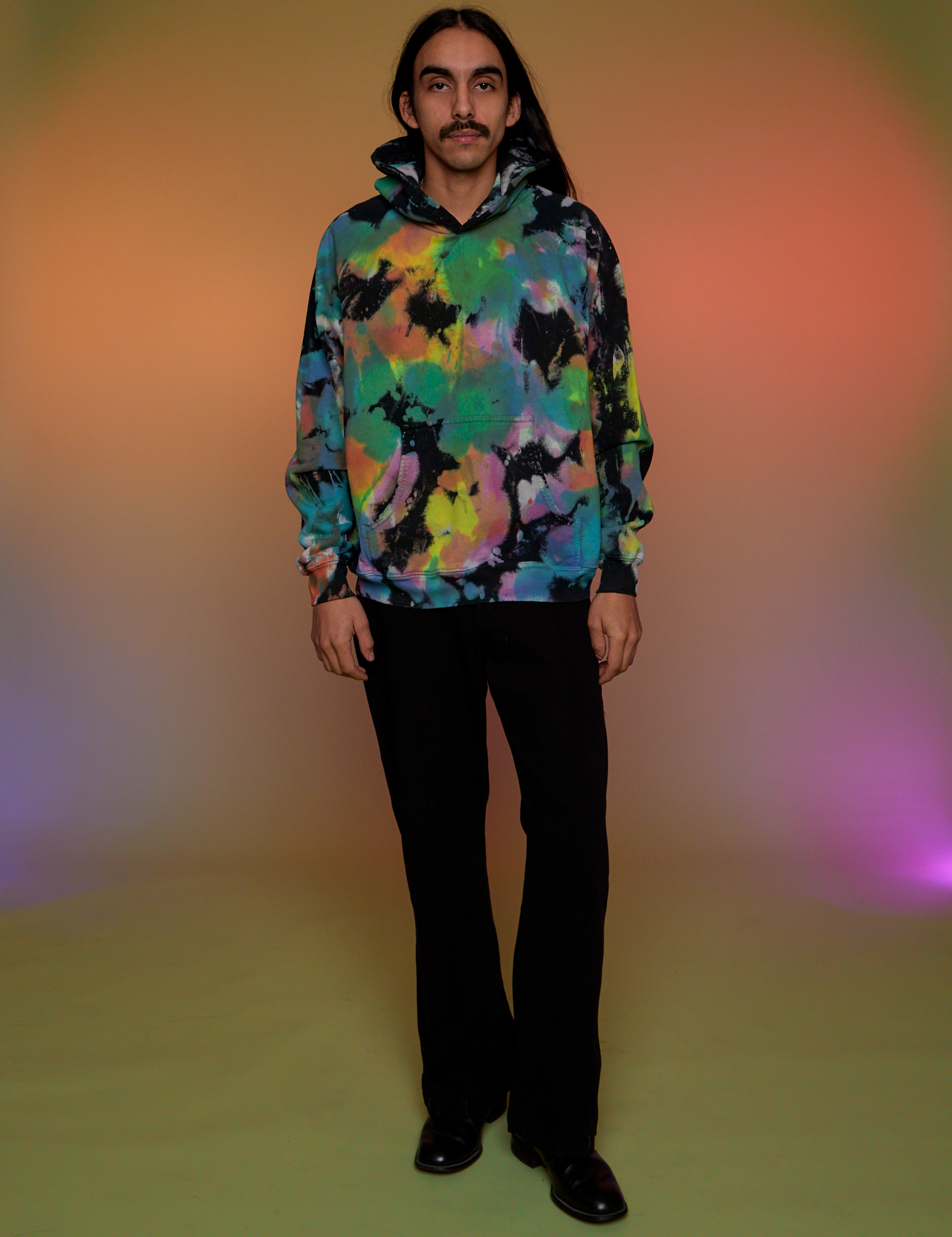 Anthony is wearing Oversized Hoodie in Rainbow Magic Waters