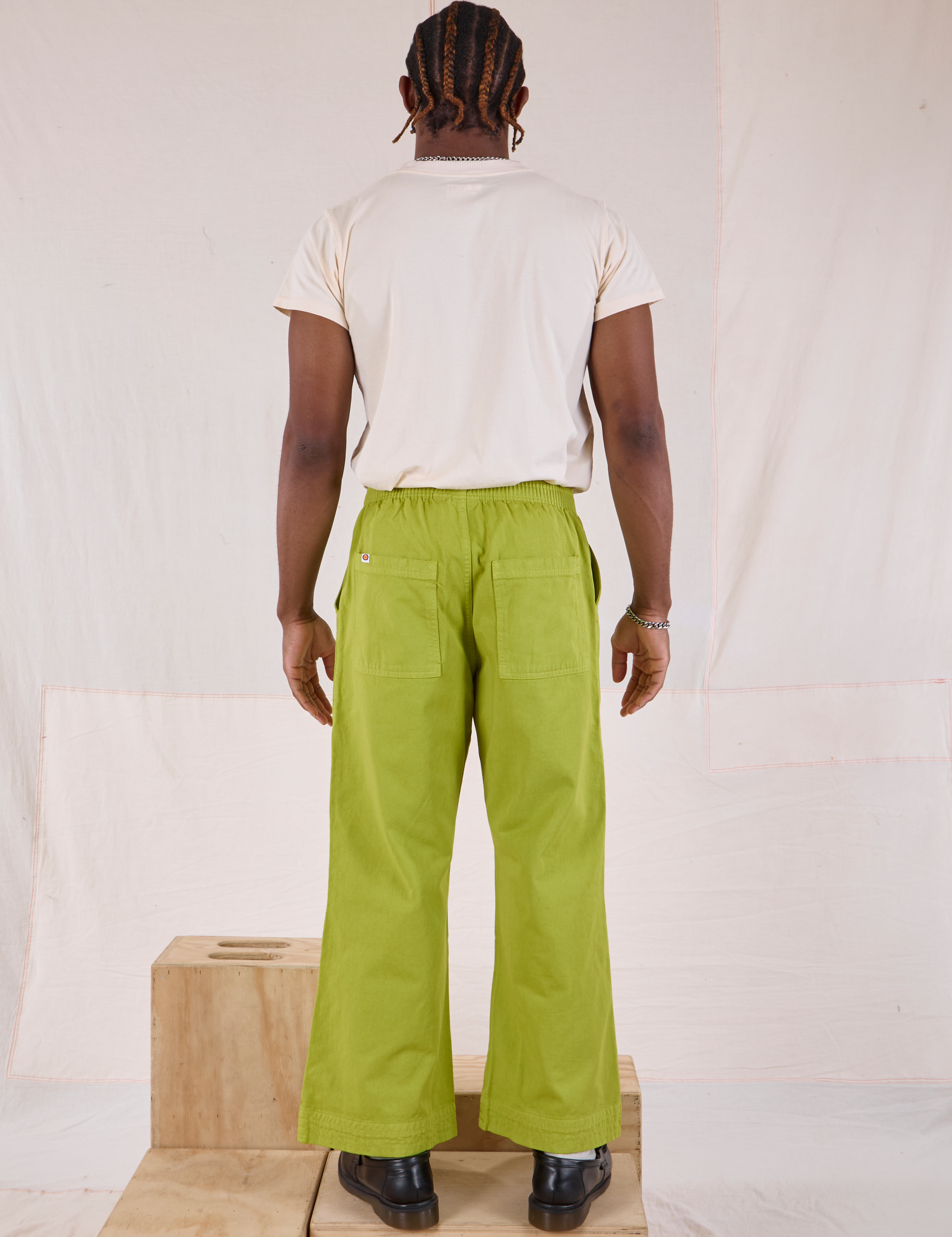 Back view of Action Pants in Gross Green and Organic Vintage Tee in Vintage Tee Off-White