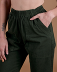 Close up of Alex's hand in the front pocket of Action Pants in Swamp Green